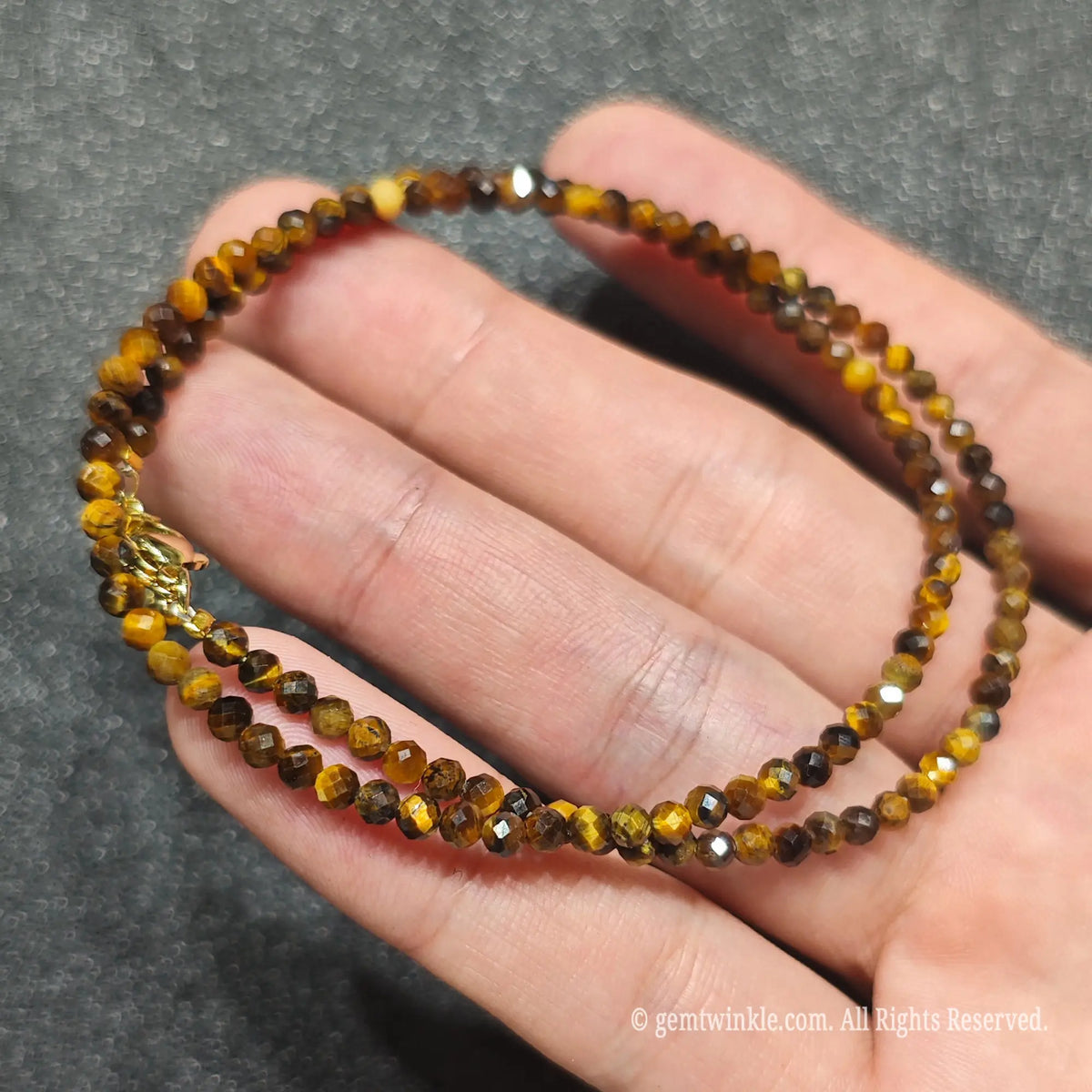 Coiled 3mm faceted Golden Tiger Eye necklace held across fingers suited for boutique reseller displays