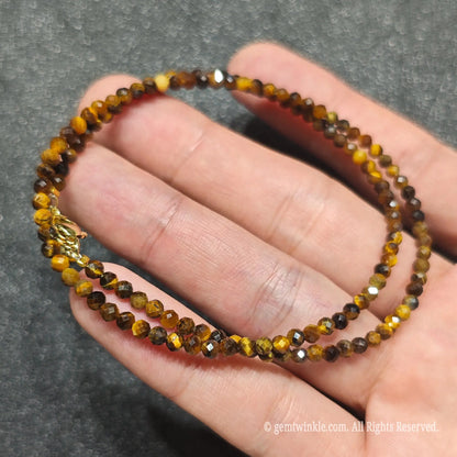 Coiled 3mm faceted Golden Tiger Eye necklace held across fingers suited for boutique reseller displays