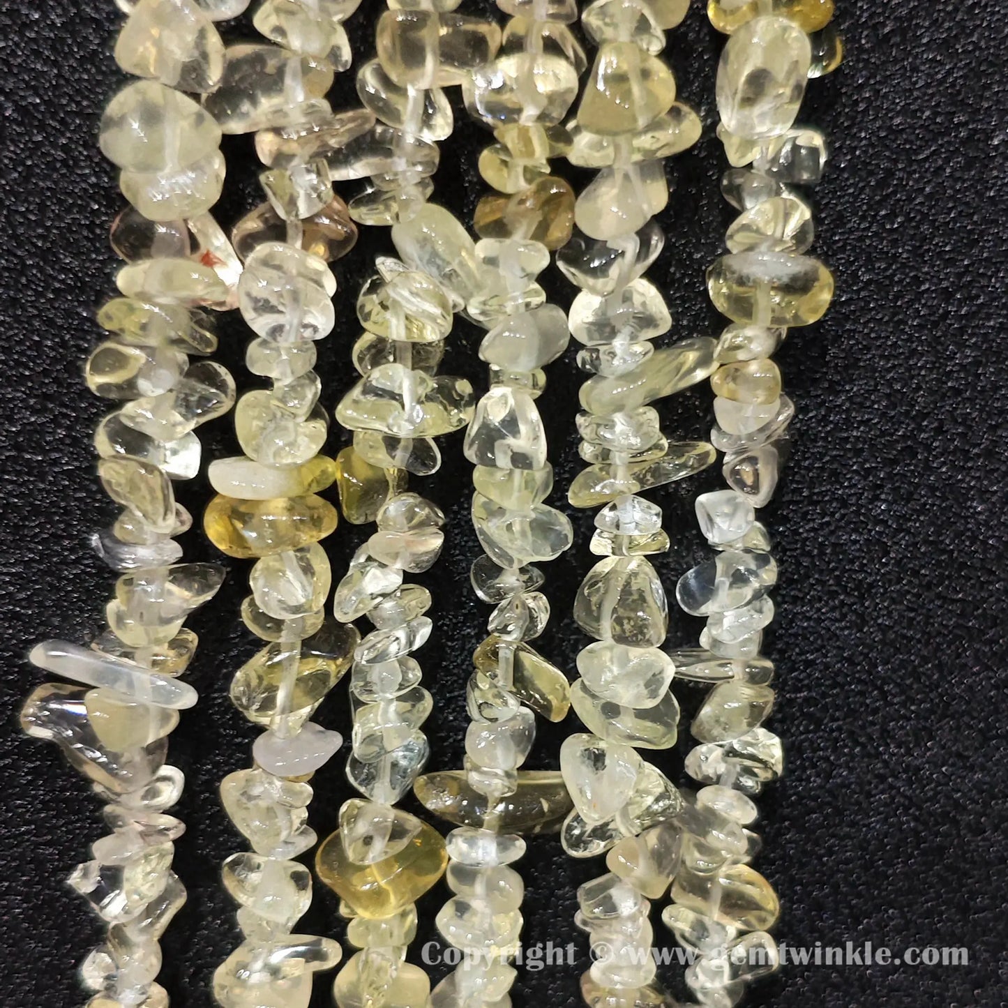 Long strand layout of clear lemon yellow quartz chip beads for jewelry crafting