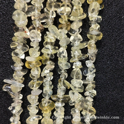Long strand layout of clear lemon yellow quartz chip beads for jewelry crafting
