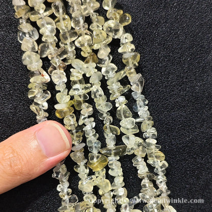 Hand holding 75cm continuous strand of sunny lemon quartz irregular chip beads
