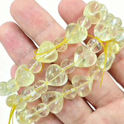 Single-strand lemon quartz heart bead bracelet held in hand showing clear pale yellow tone