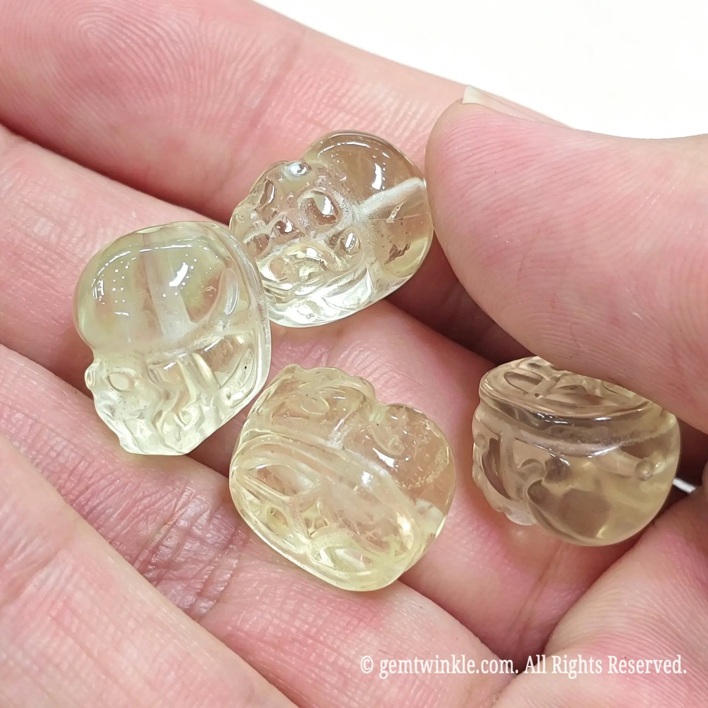 Close up view of translucent lemon quartz Pixiu beads showing clear back carving details
