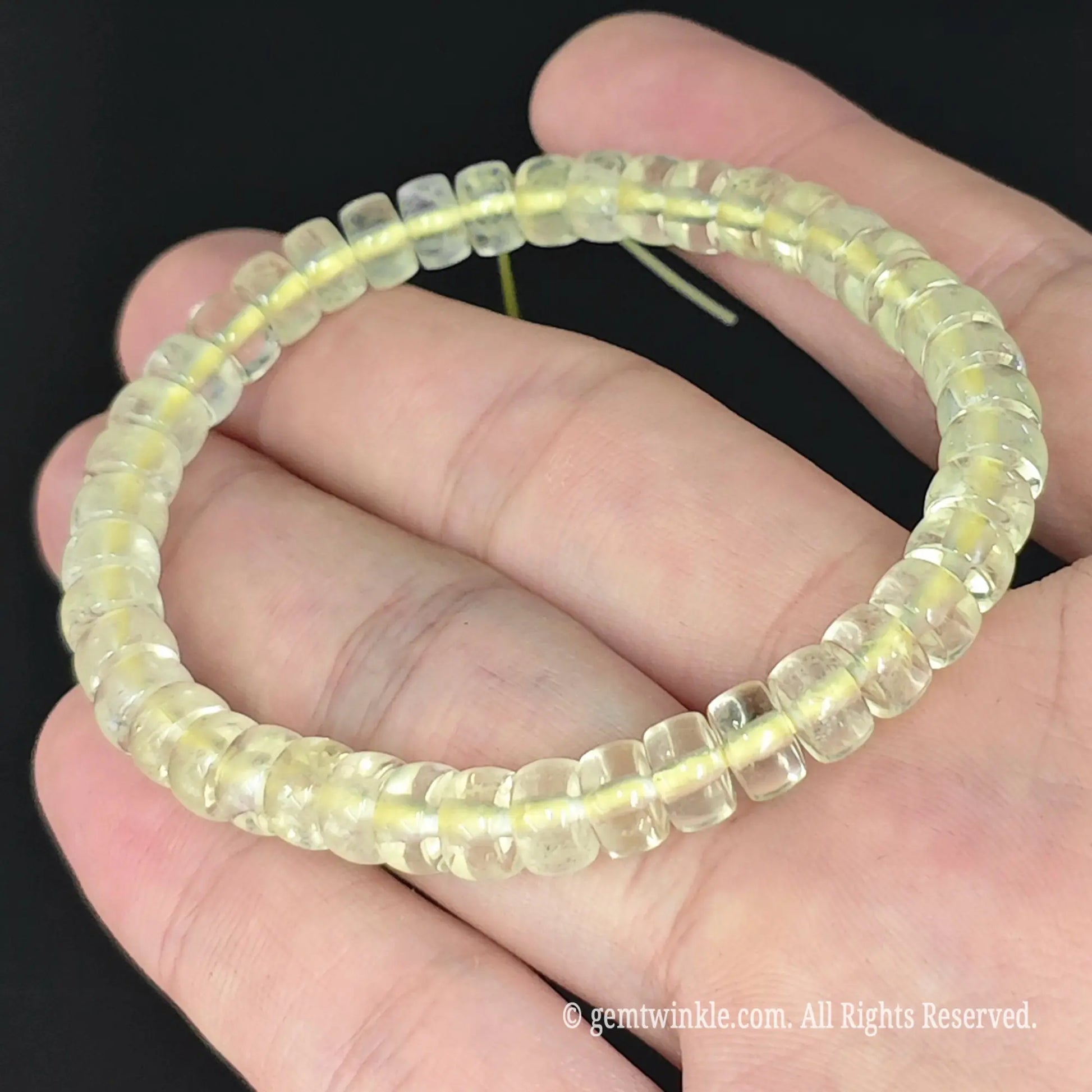 translucent yellow lemon quartz saucer bead stretch strand held in hand
