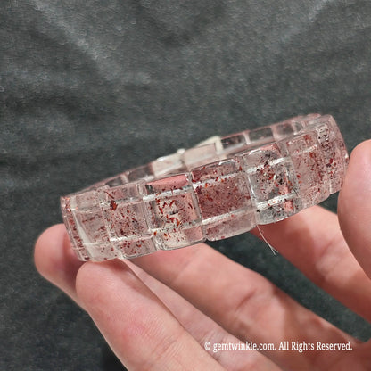 Close up view of lepidocrocite included quartz flat bead strand showing natural iron oxide mineral speckles