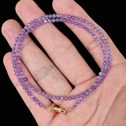 3-4mm light amethyst faceted bead strand held in hand displaying pale lavender hue