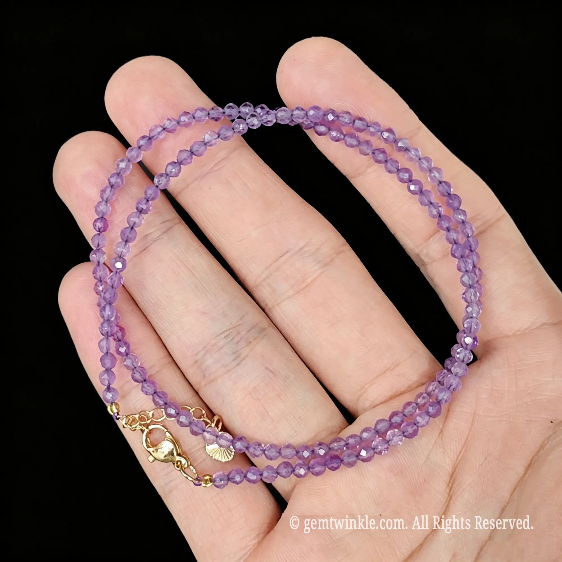 detail view of gold tone alloy clasp and 5cm extender chain on light amethyst necklace