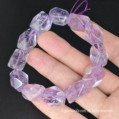 top view of light purple amethyst freeform bead stretch bangle held in palm