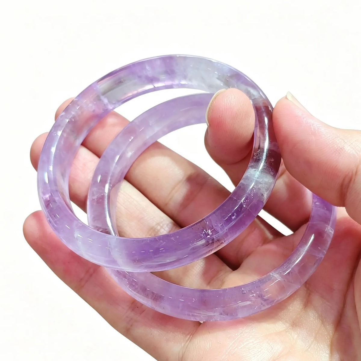 Light purple amethyst gemstone bangle bracelet presented on hand for boutique stock