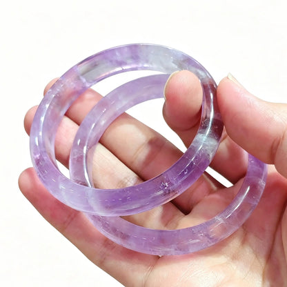 Light purple amethyst gemstone bangle bracelet presented on hand for boutique stock