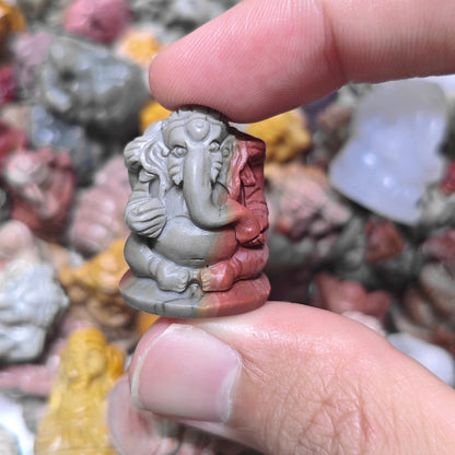 Side profile view of a mini Lord Ganesha statue held in hand displaying carved ear and trunk details