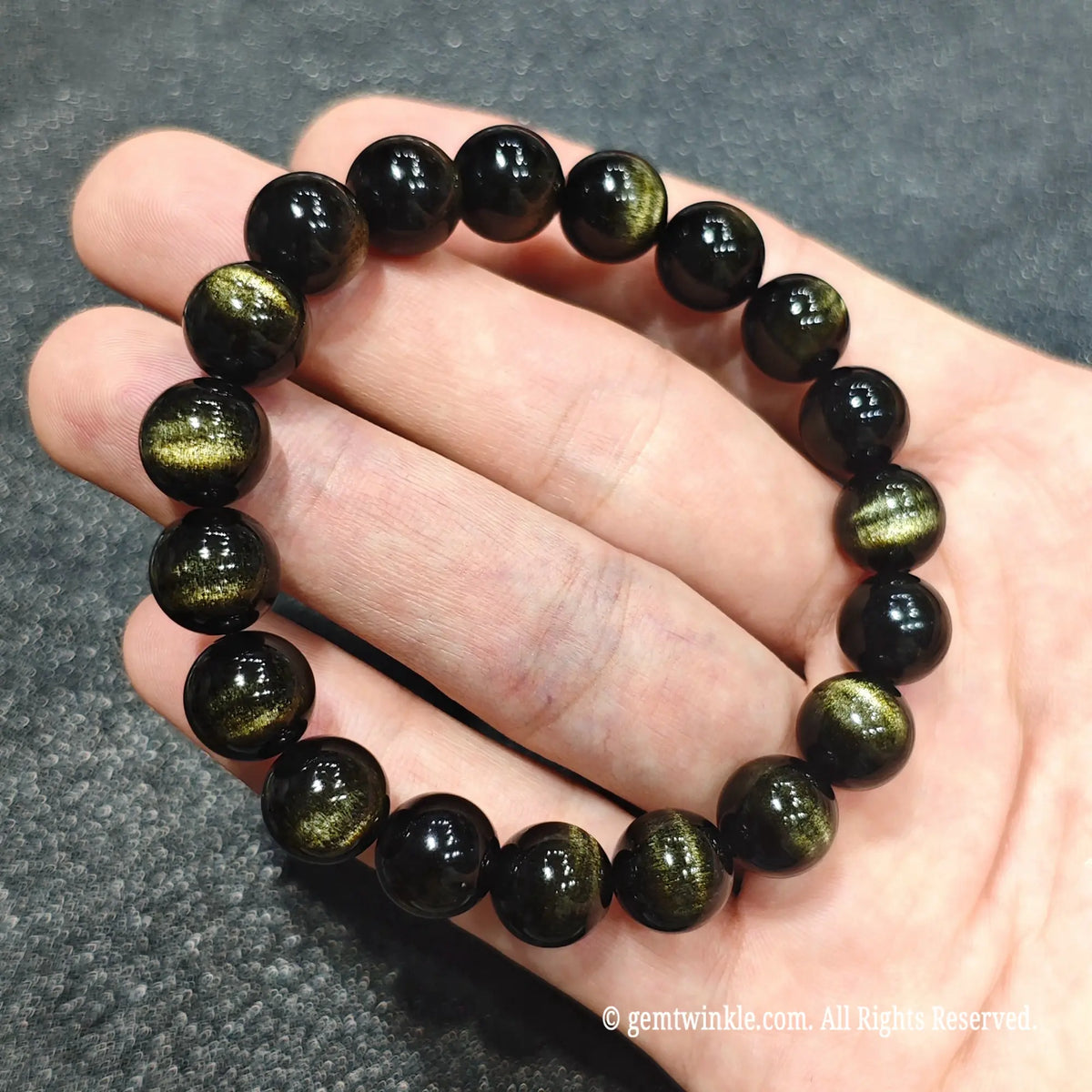 Premium select 10mm gold sheen obsidian beaded bangle highlighting strong cat's eye lines against dark background