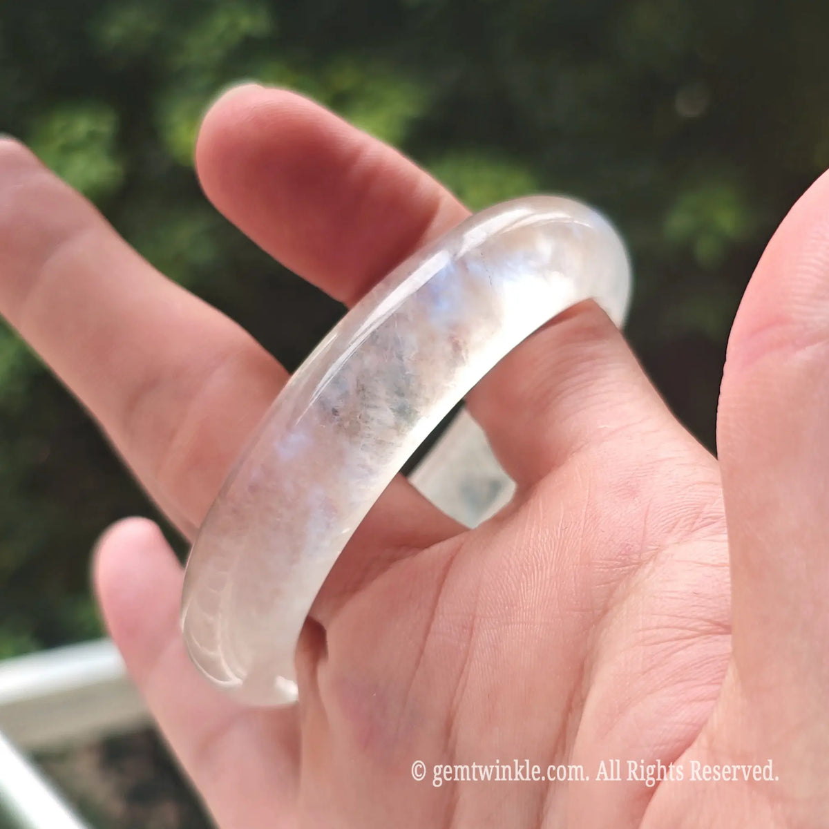 Close up of a premium blue moonstone bangle demonstrating its vibrant floating optical adularescence
