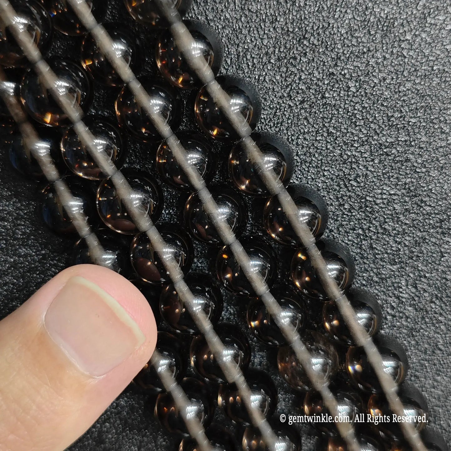 Close up of tiny natural micro 2mm and 3mm ice obsidian beads ideal for dainty minimalist jewelry making