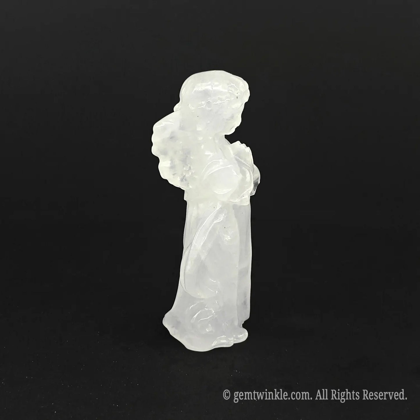 Side view of a hand-carved natural milky quartz angel figurine showing detailed wings and soft white opaque mineral texture
