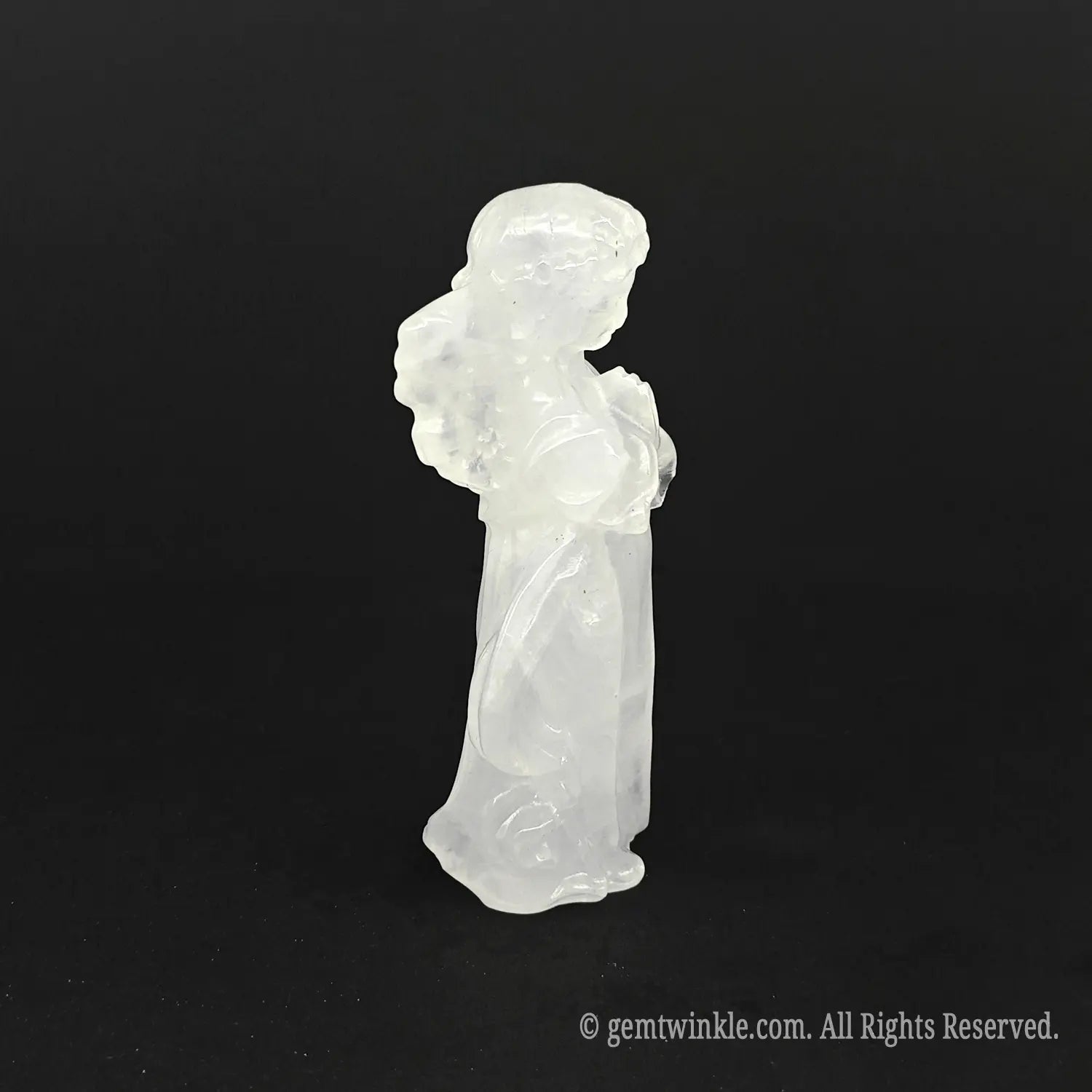 Side view of a hand-carved natural milky quartz angel figurine showing detailed wings and soft white opaque mineral texture