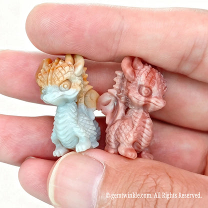 Miniature natural Alashan agate winged dragon figurines resting on open palm displaying detailed back scales and 2.5cm height