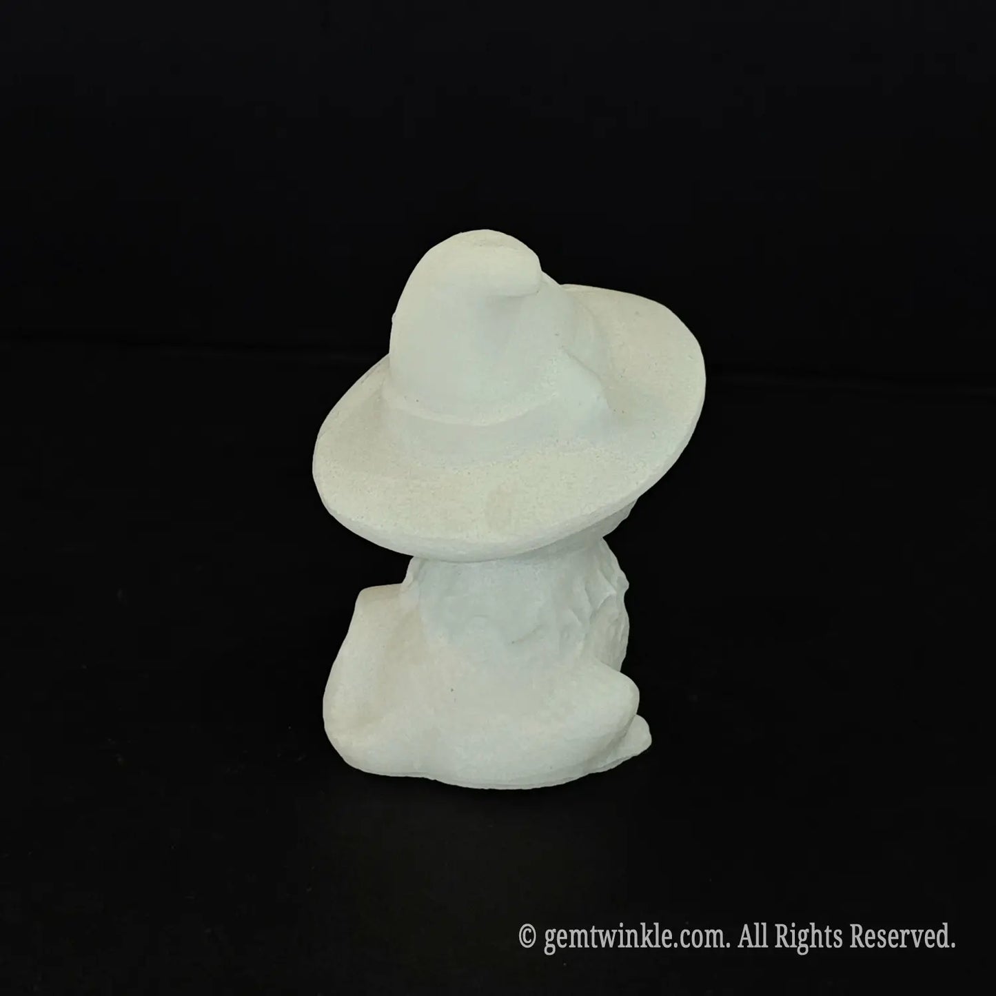 The back view of a standalone white marble witch cat figurine showing the smooth back of the pointed wizard hat and tail detail