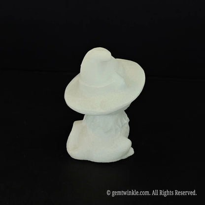 The back view of a standalone white marble witch cat figurine showing the smooth back of the pointed wizard hat and tail detail