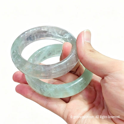 Assorted mint green fluorite natural stone bangles displayed together showing size and quality grade variations