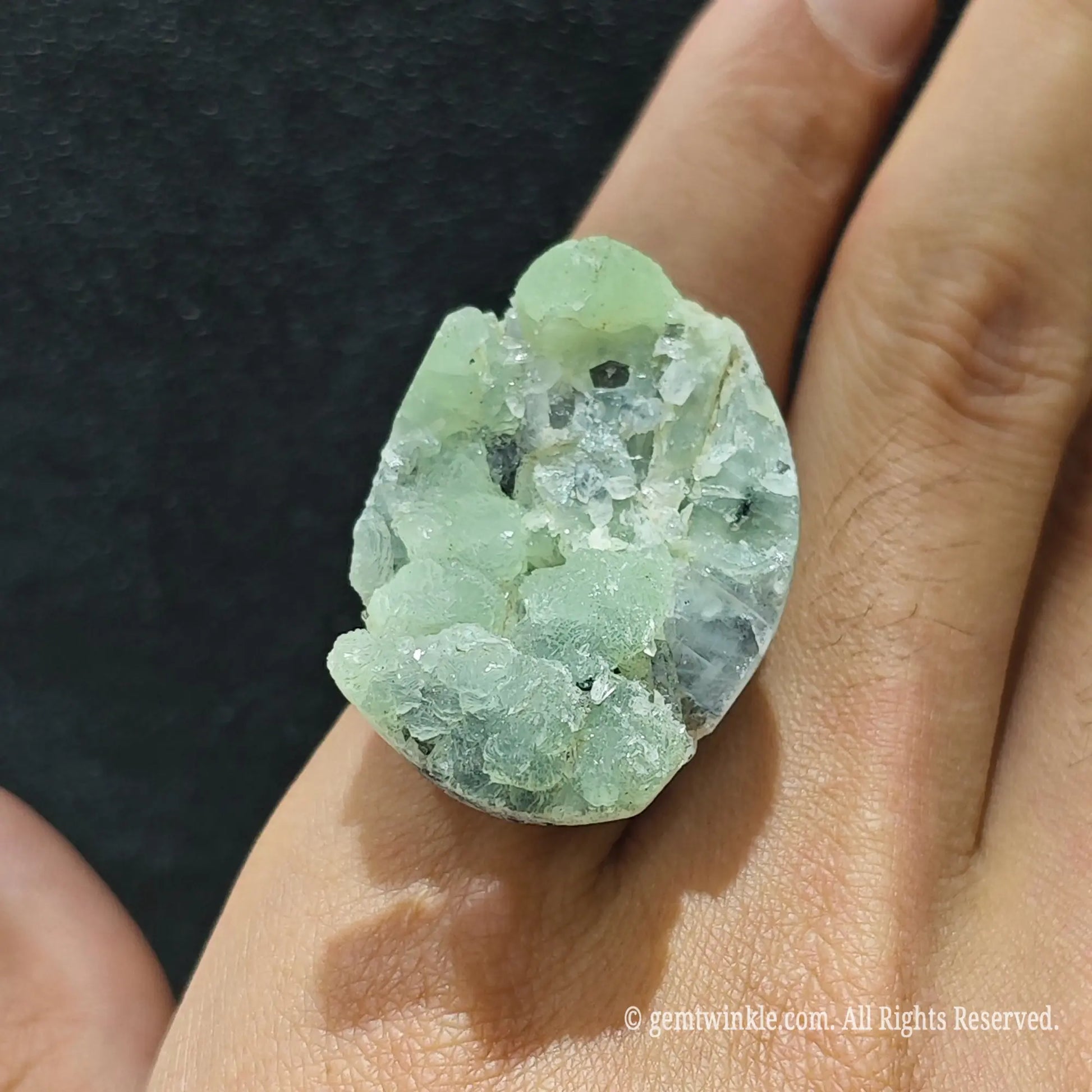Mint green fluorite statement ring top view on finger displaying 25-35mm raw crystal formation and open setting