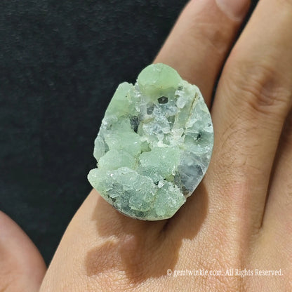 Mint green fluorite statement ring top view on finger displaying 25-35mm raw crystal formation and open setting