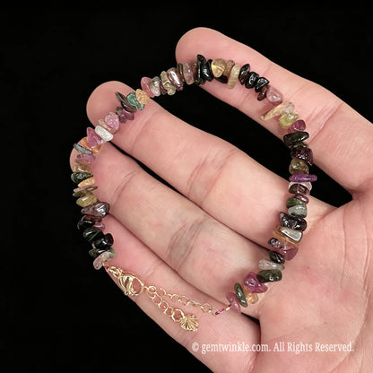mixed tourmaline raw nugget bracelet held across fingers displaying rainbow colors