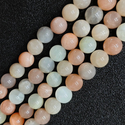 Macro closeup of natural moonstone sunstone blend smooth round beads showing soft peach tones and sheen