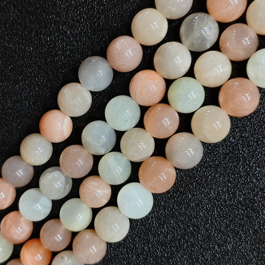 Macro closeup of natural moonstone sunstone blend smooth round beads showing soft peach tones and sheen