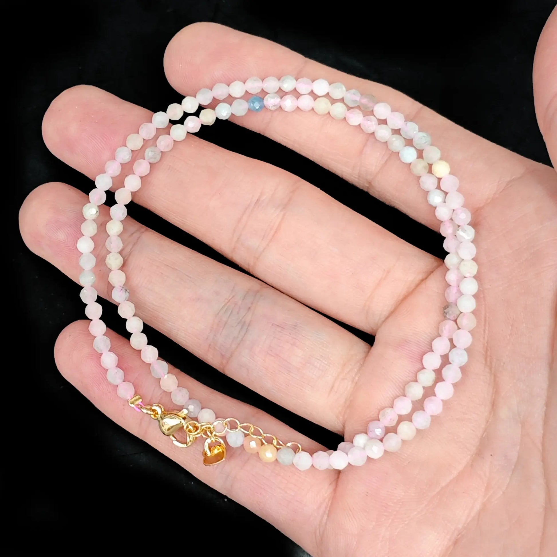 morganite micro faceted bead strand held in hand with gold clasp