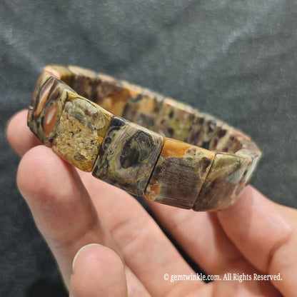 Side view of a mosaic agate bar cut cuff showcasing terracotta red, yellow, and grey mineral textures