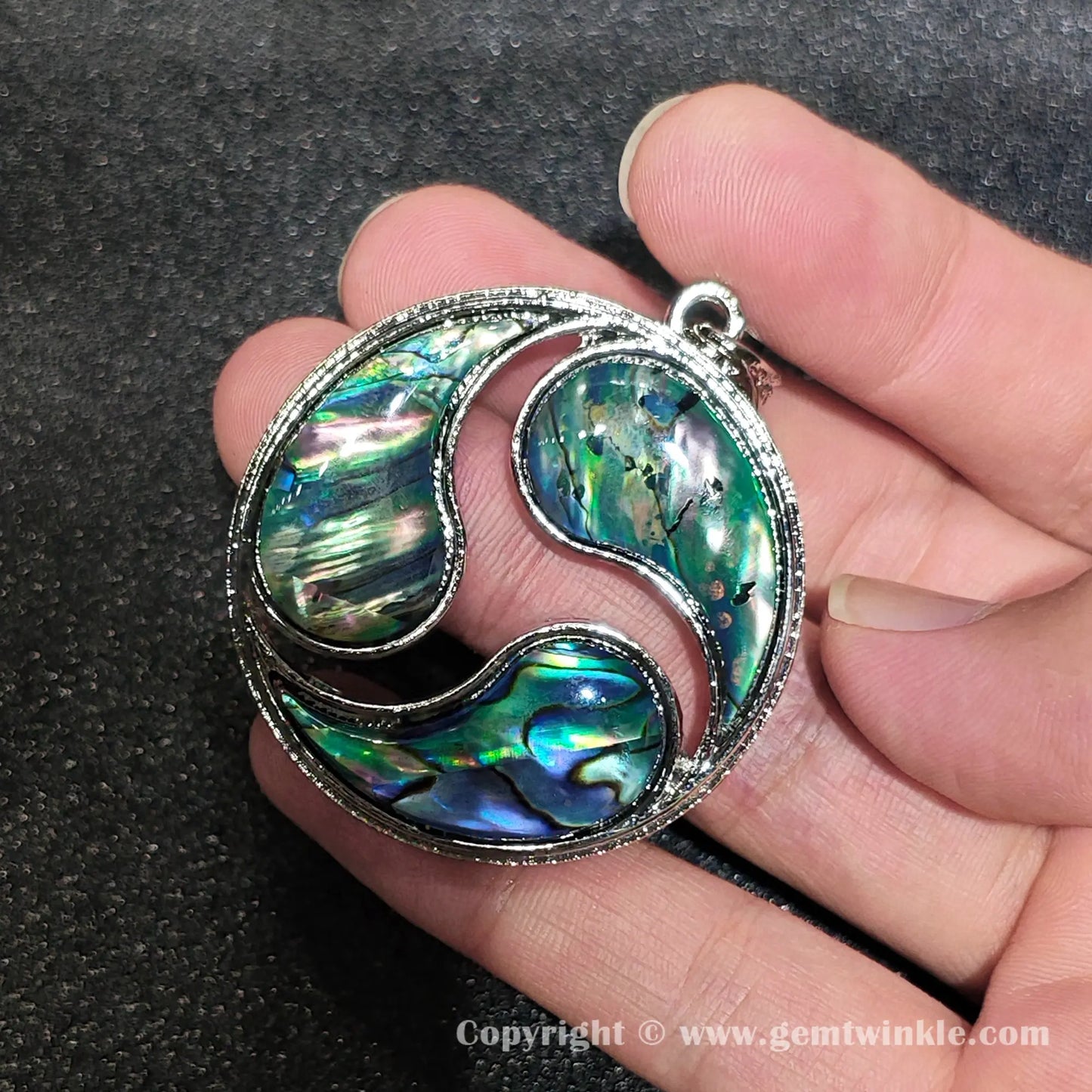 Close up handheld perspective showing top bail attachment and colorful patchwork shell reflections