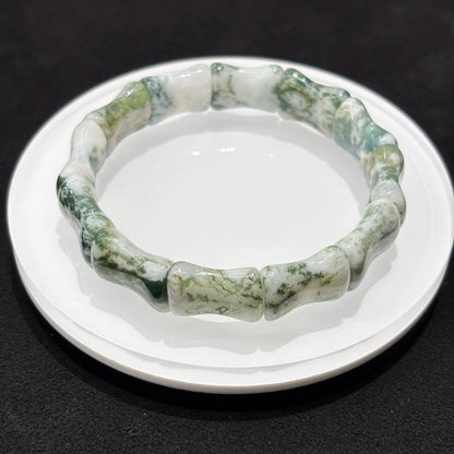 Lifestyle photo of a natural moss agate bamboo bead bracelet, styled with other accessories for a boho-chic look.