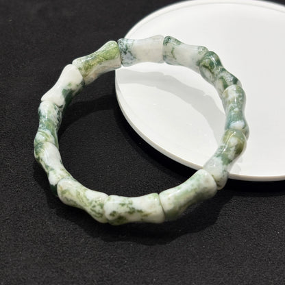 Two natural moss agate bamboo bead bracelets stacked together on a white plate, highlighting the elegant design and craftsmanship.
