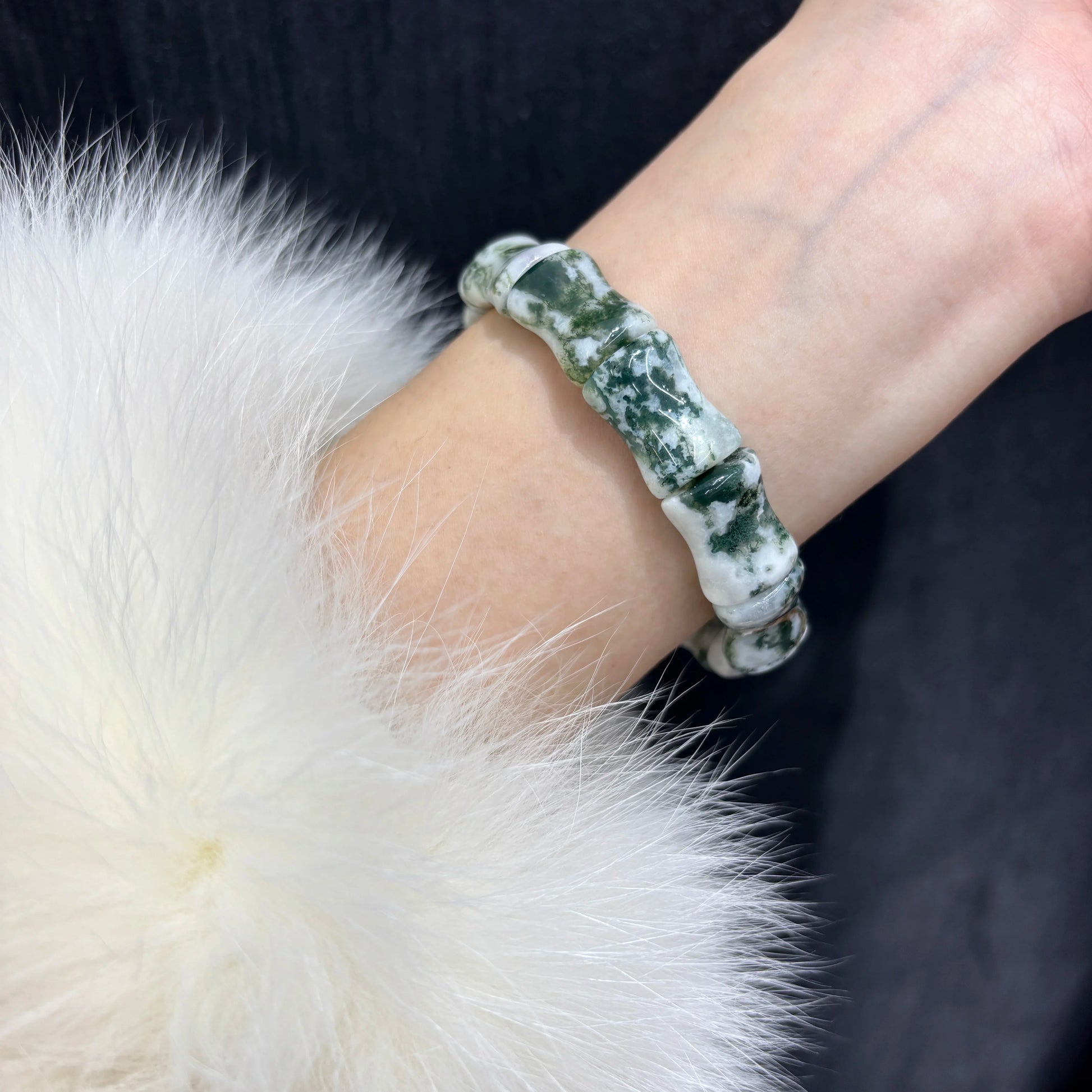 A person wearing a natural moss agate bamboo bead bracelet on their wrist, demonstrating the fit and style of the jewelry.