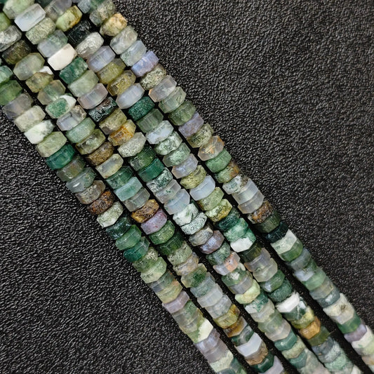 Macro closeup of natural moss agate faceted rondelle beads 6x3mm showing green botanical inclusions