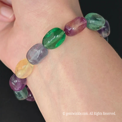 side view of multi-color fluorite drum bead stretch bracelet on wrist