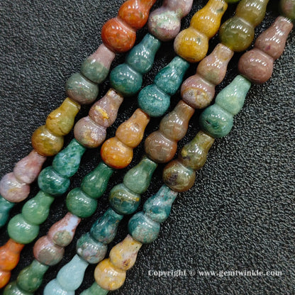 Angled view of multi color natural ocean jasper gourd shaped gemstone strands