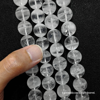 detailed view of large size white phantom quartz round beads under clear lighting