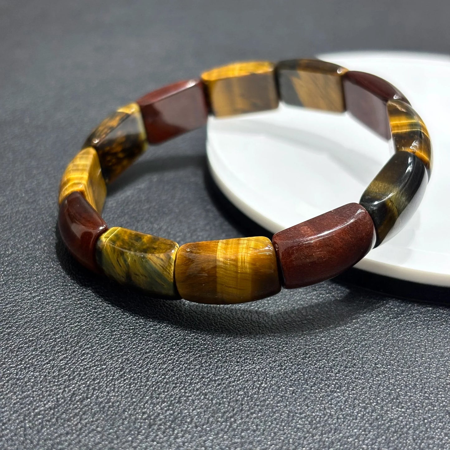 Multicolor Tiger Eye Bangles placed side by side on a white plate, comparing color variations and bead alignment.