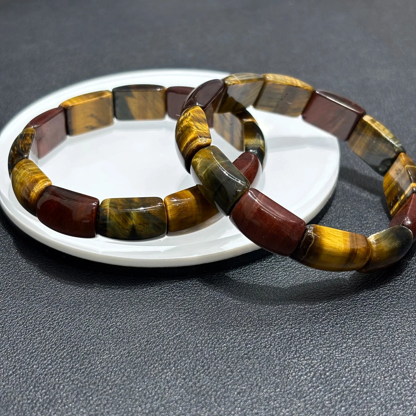 Multicolor Tiger Eye Bangles stacked on a white plate, showcasing the 3-color pattern and rectangular bead texture.