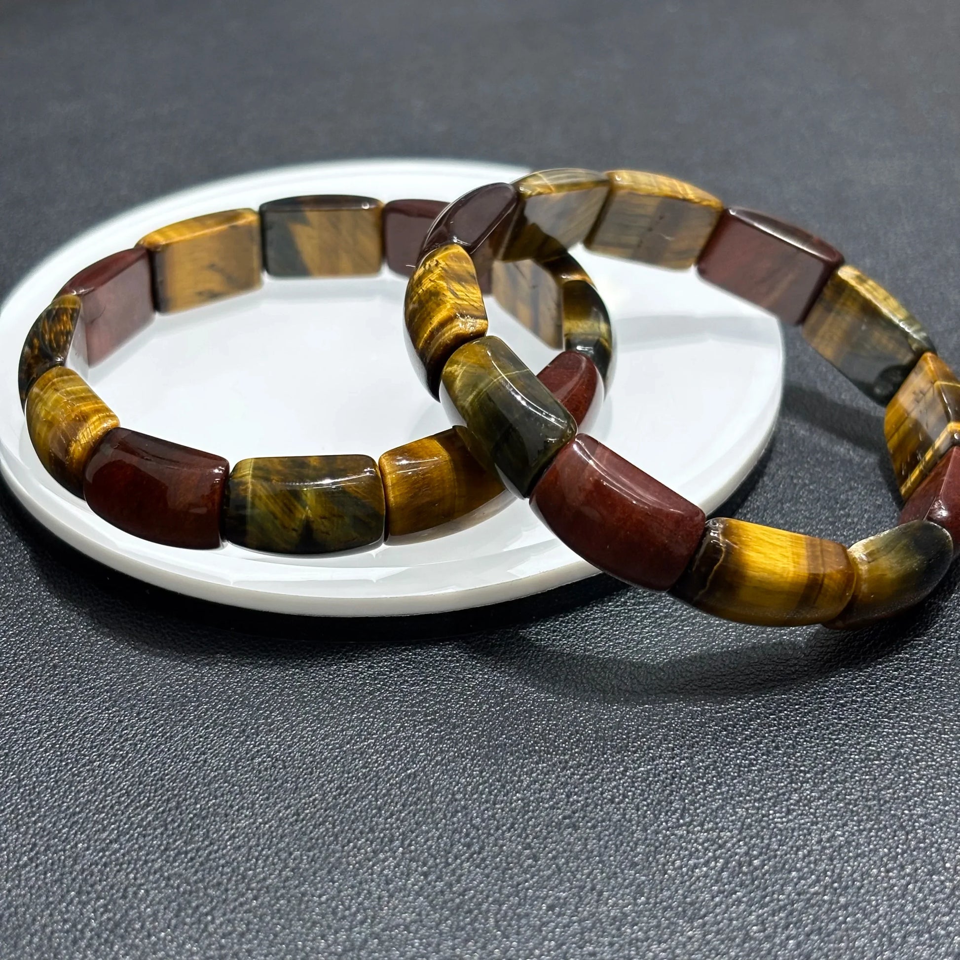 Multicolor Tiger Eye Bangles stacked on a white plate, showcasing the 3-color pattern and rectangular bead texture.
