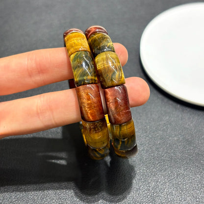 Close-up of a hand holding the Multicolor Tiger Eye Bangle, highlighting the 11x17mm rectangular bead size and vibrant color bands.