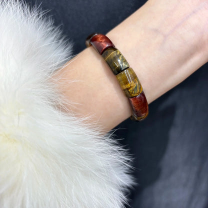 Wrist shot of the Multicolor Tiger Eye Bangle, paired with a fluffy white sleeve, demonstrating the fit and stylish look.