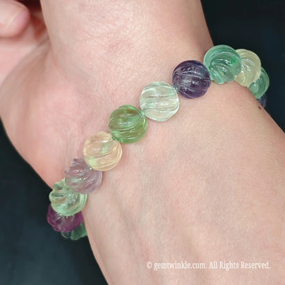Multicolor fluorite pumpkin bead stretch bracelet styled on wrist displaying green and purple shades with comfortable fit