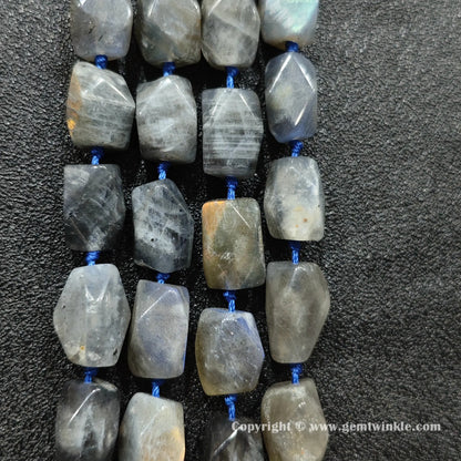 multiple chunky strands of grey moonstone faceted barrel beads on dark texture