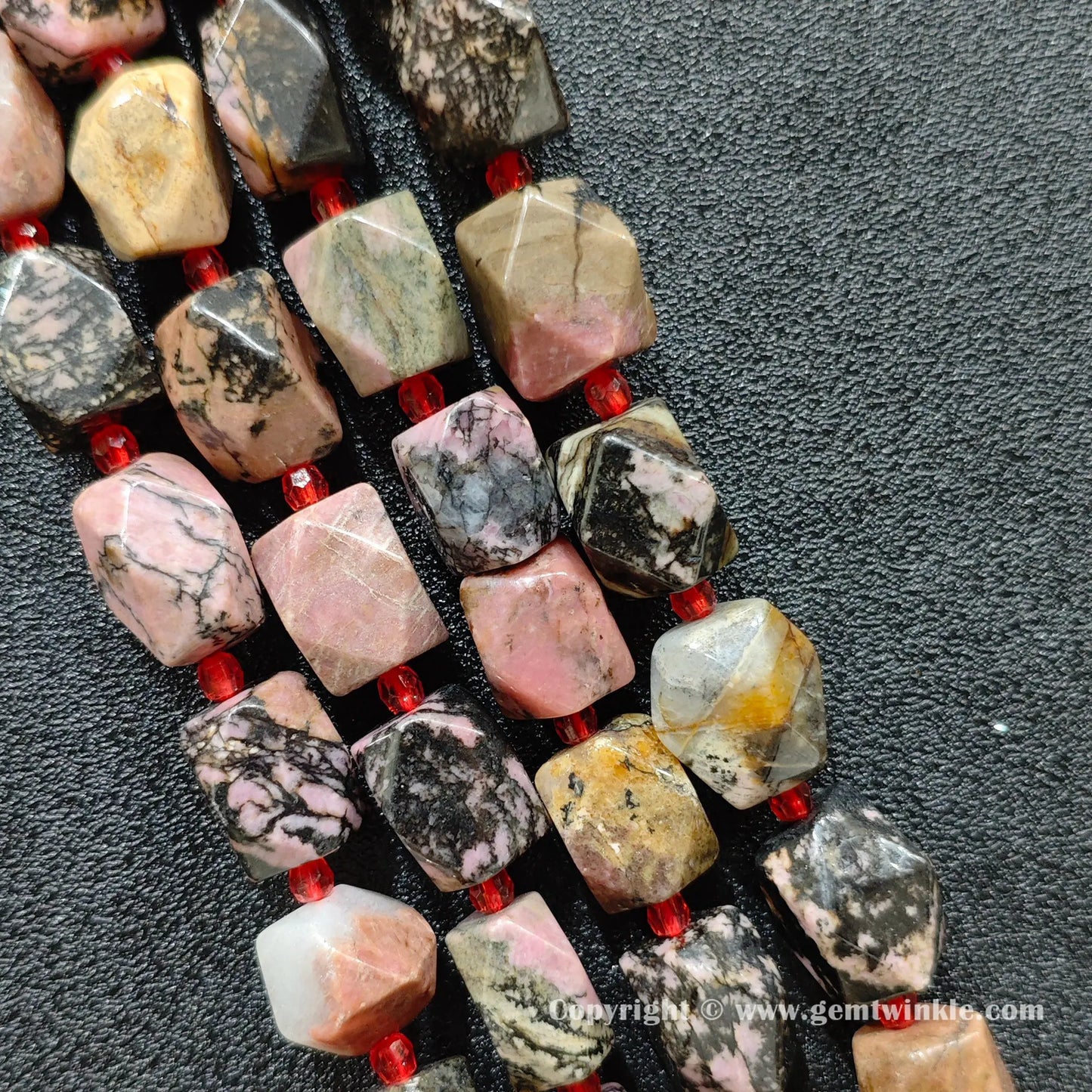 multiple strands of faceted black veined rhodonite barrel beads