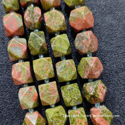 handheld scale view of 11mm faceted unakite barrel beads showing size