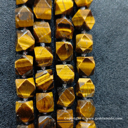 multiple strands of faceted yellow tiger eye barrel beads held in hand