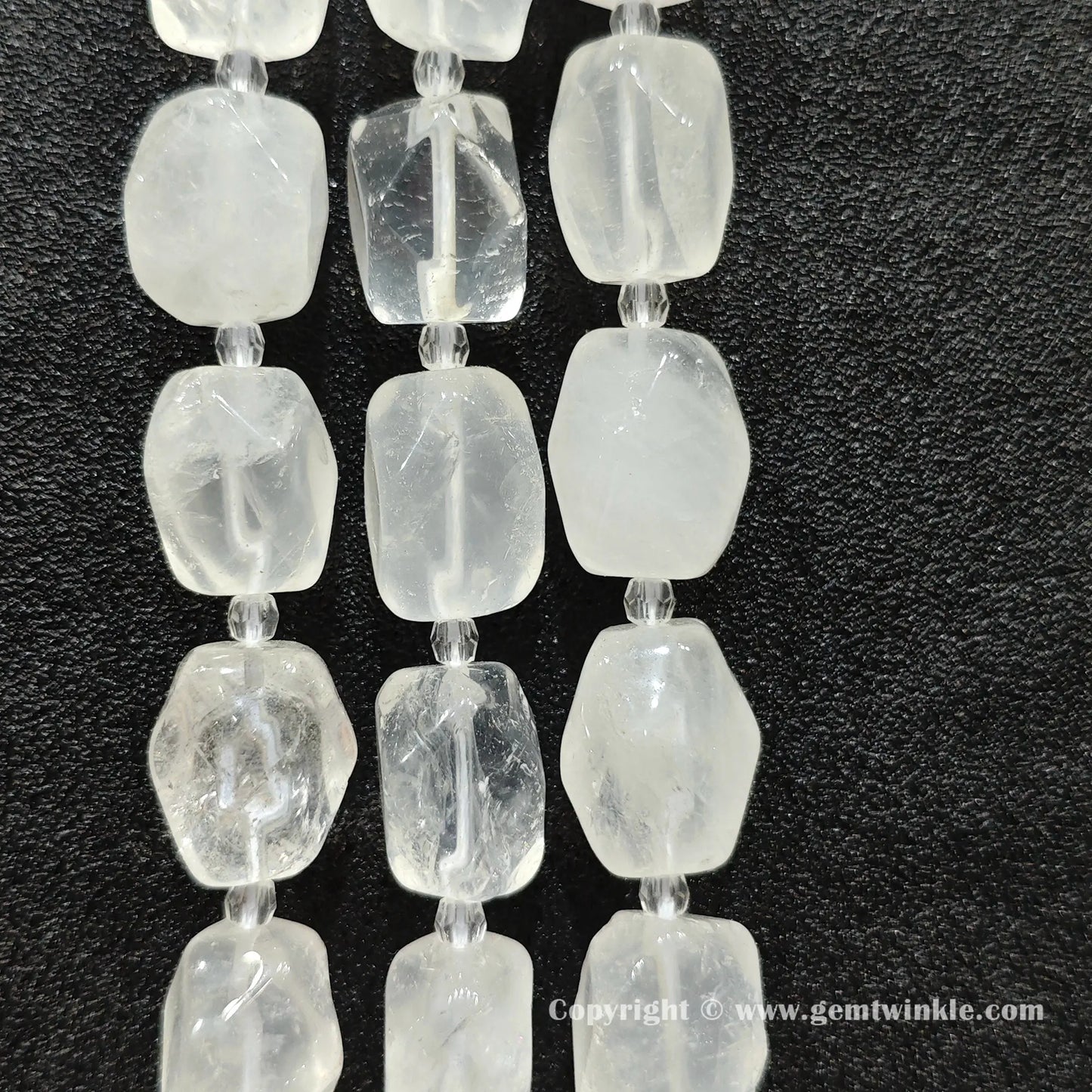 multiple strands of frosty clear quartz faceted barrel beads on dark texture